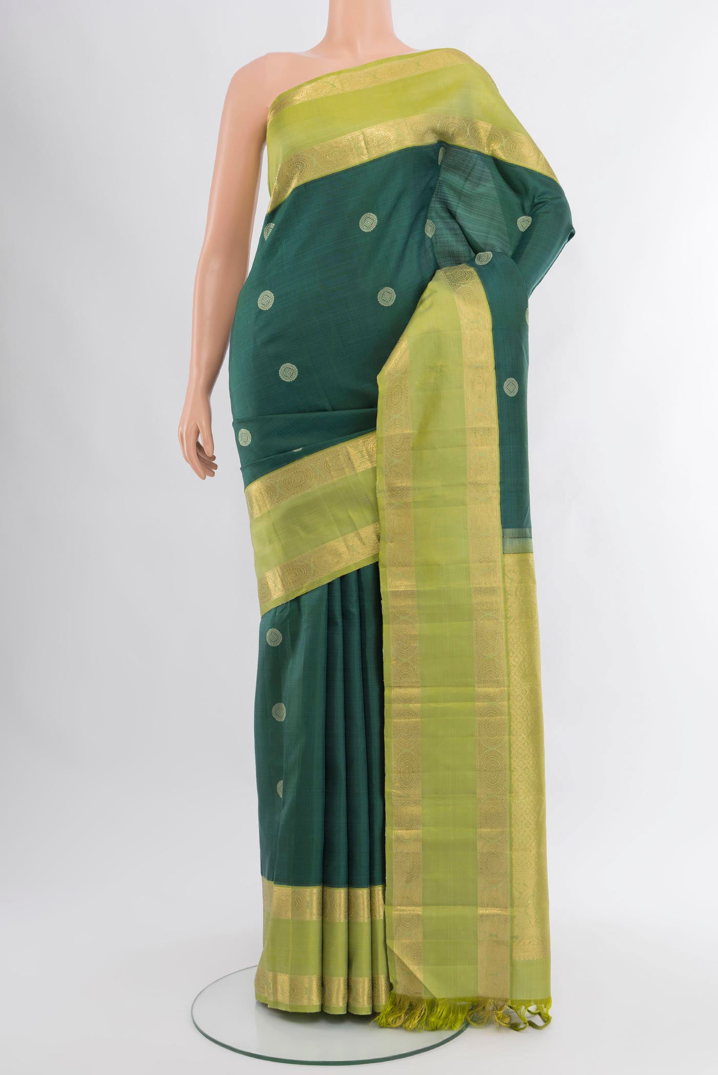 Bottle Green Kanchipuram Silk Saree with Zari Butta on the body and Zari Border.  displayed on a mannequin