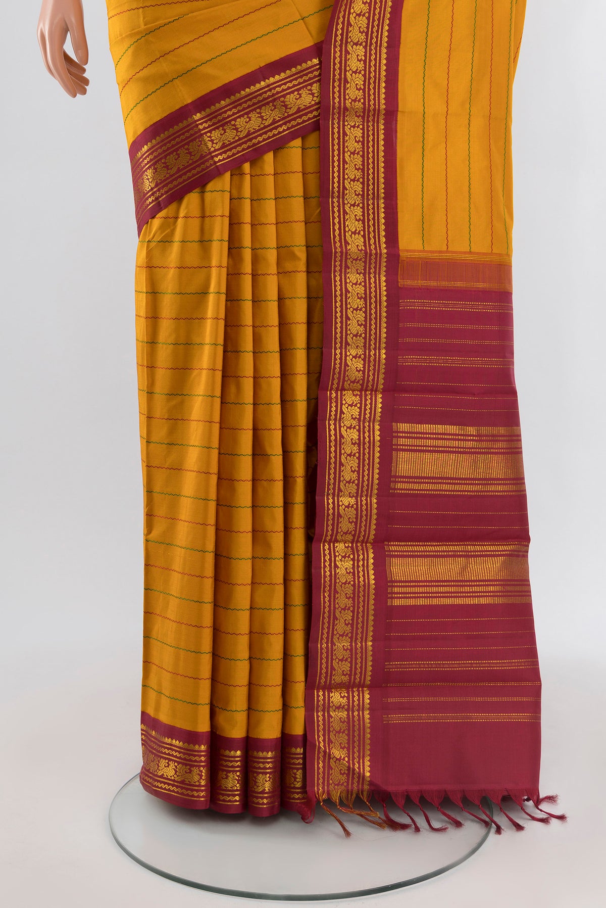 Pleats and pallu of Mustard Kanjivaram Silk Saree with Veldhari on the body and Zari Border. 