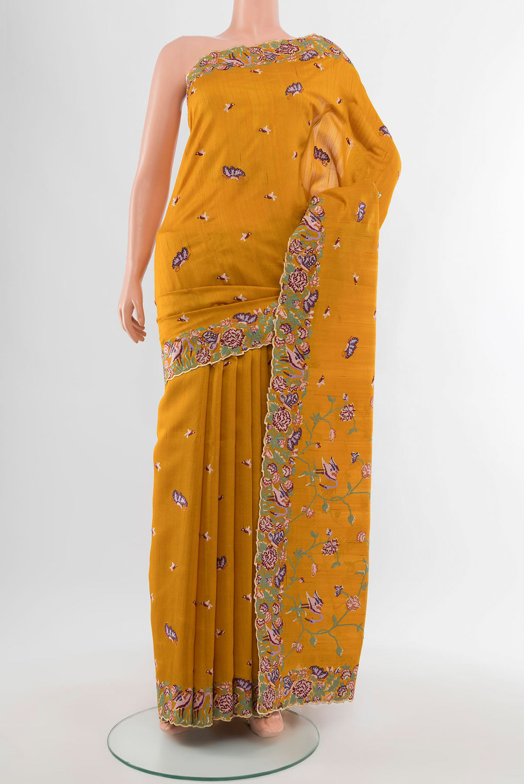 Mustard Art Silk Saree with Embroidery on the body and Silk Border.  displayed on a mannequin