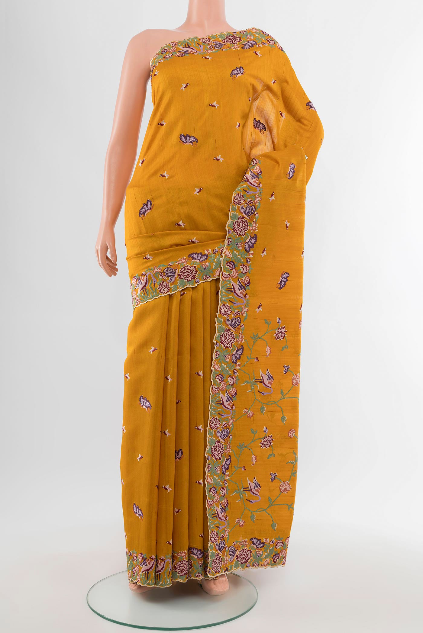 Mustard Art Silk Saree with Embroidery on the body and Silk Border.  displayed on a mannequin