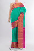 Turquoise Kanjivaram Silk Saree with Zari Butta on the body and Zari Border.  displayed on a mannequin