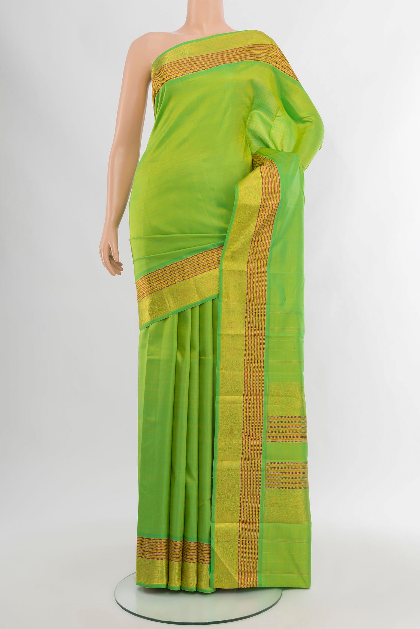 Parrot Green Kanchipuram Silk Saree with Zari Butta on the body and Zari Border.  displayed on a mannequin