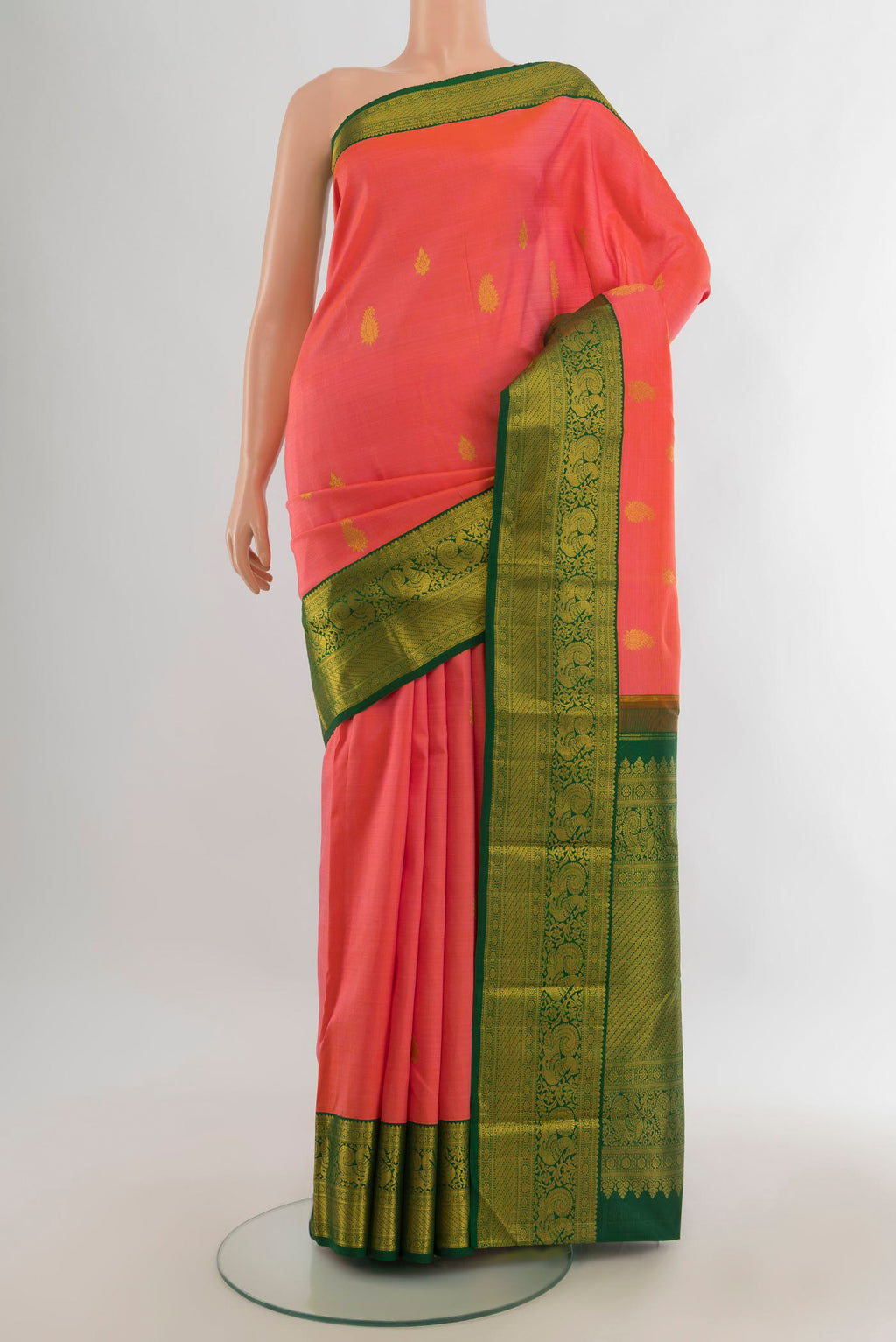 Pure Silk Coral Kanjivaram Saree with Zari Butta on the body and Zari Border.  displayed on a mannequin