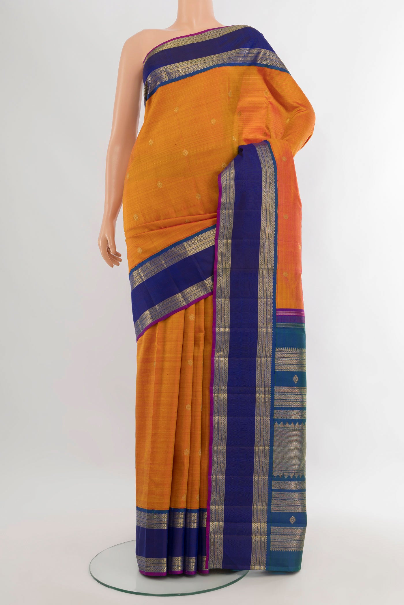 Rust Kanjivaram Silk Saree with Zari Butta on the body and Zari Border.  displayed on a mannequin