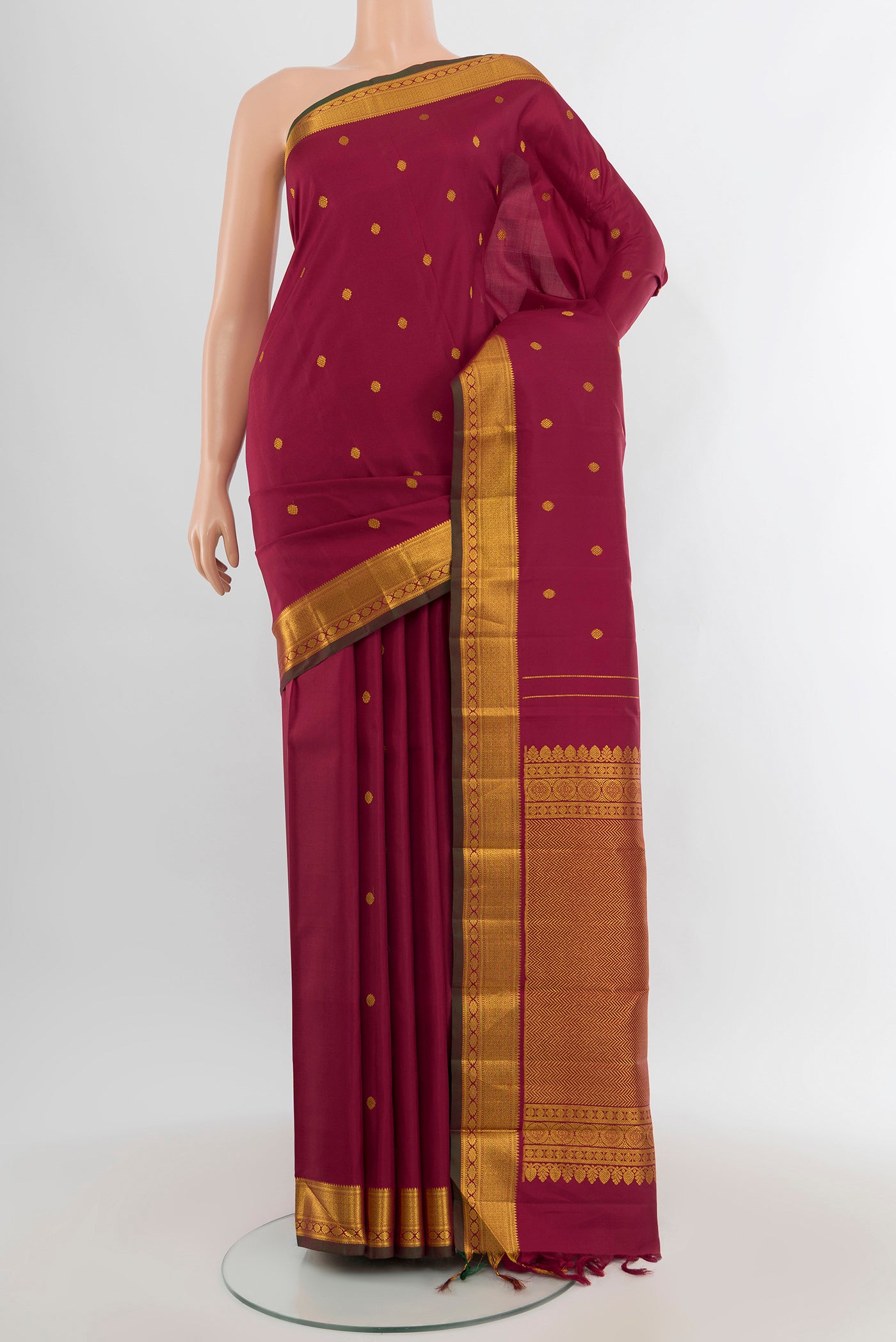 Maroon Kanchipuram Silk Saree with Zari Butta on the body and Zari Border.  displayed on a mannequin