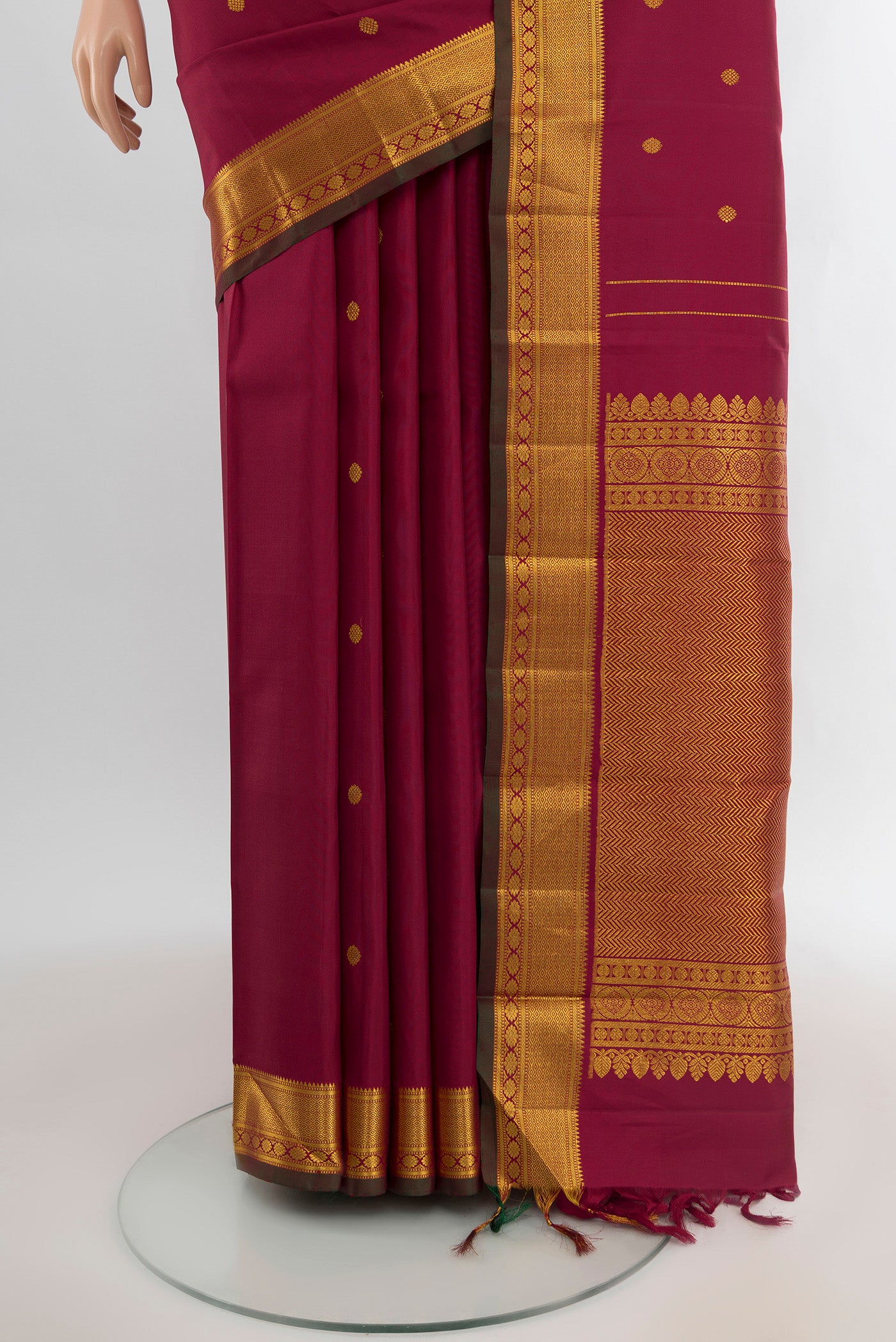 Pleats and pallu of Maroon Kanchipuram Silk Saree with Zari Butta on the body and Zari Border. 