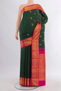 Pure Silk Bottle Green Kanjivaram Saree with Zari Butta on the body and Zari Border.  displayed on a mannequin