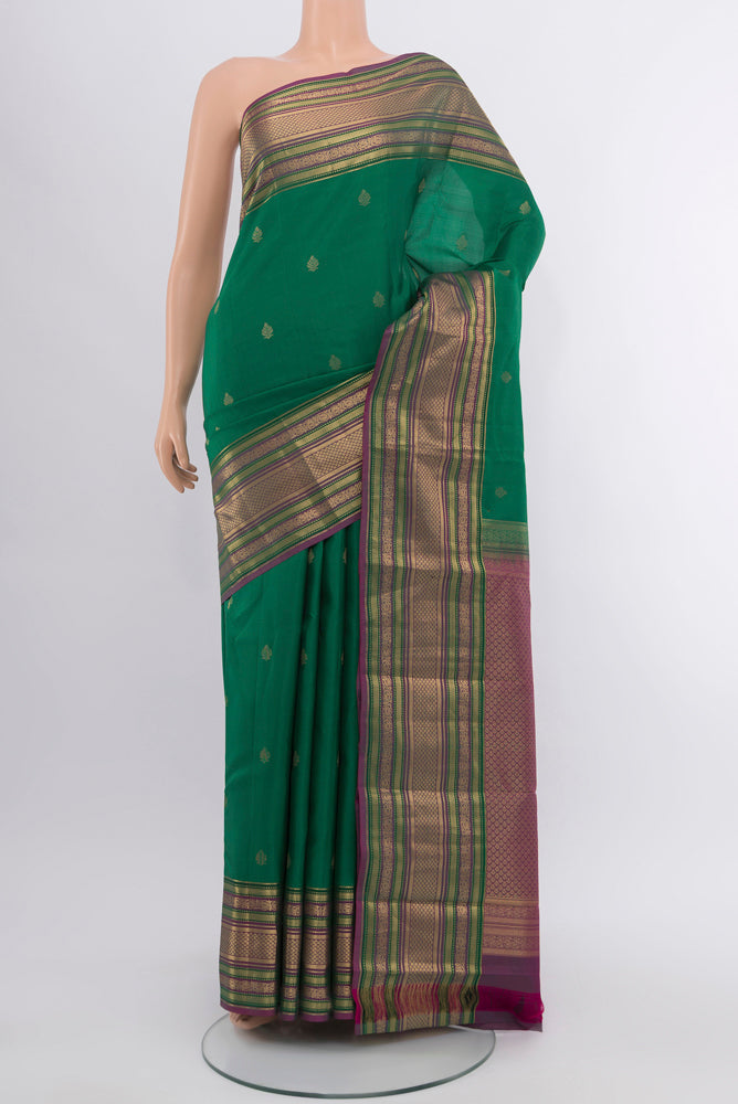 Peacock Blue Kanchipuram Silk Saree with Zari Butta on the body and Silk Border.  displayed on a mannequin