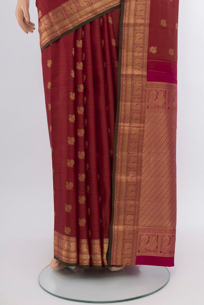 Pleats and pallu of Maroon Kanchipuram Silk Saree with Zari Butta on the body and Silk Border. 