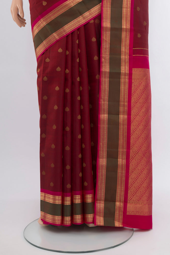 Pleats and pallu of Maroon Kanchipuram Silk Saree with Zari Butta on the body and Silk Border. 