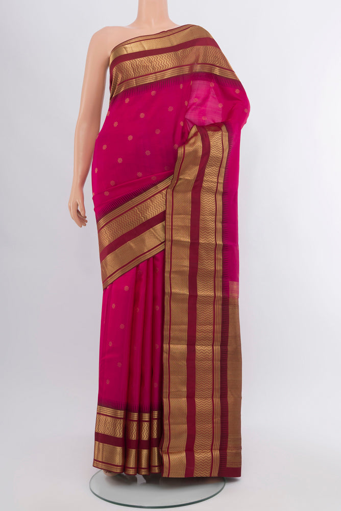 Magenta Kanjivaram Silk Saree with Zari Butta on the body and Silk Border.  displayed on a mannequin
