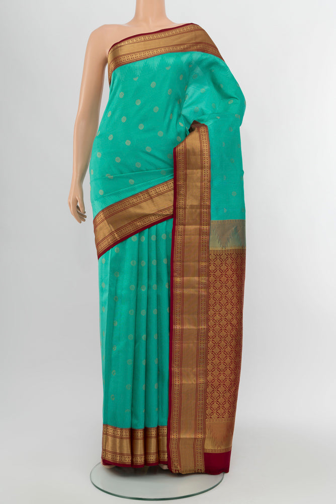 Sky Blue Kanchipuram Silk Saree with Zari Butta on the body and Silk Border.  displayed on a mannequin