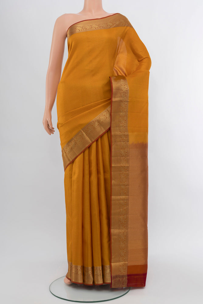 Mustard Kanchipuram Silk Saree with Zari Butta on the body and Silk Border.  displayed on a mannequin