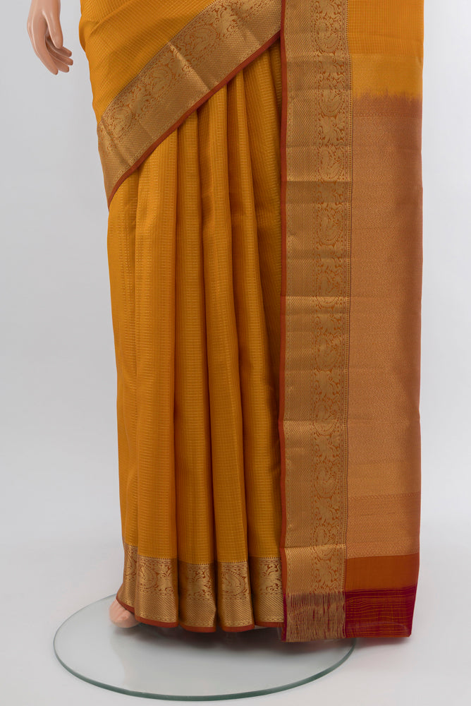 Pleats and pallu of Mustard Kanchipuram Silk Saree with Zari Butta on the body and Silk Border. 