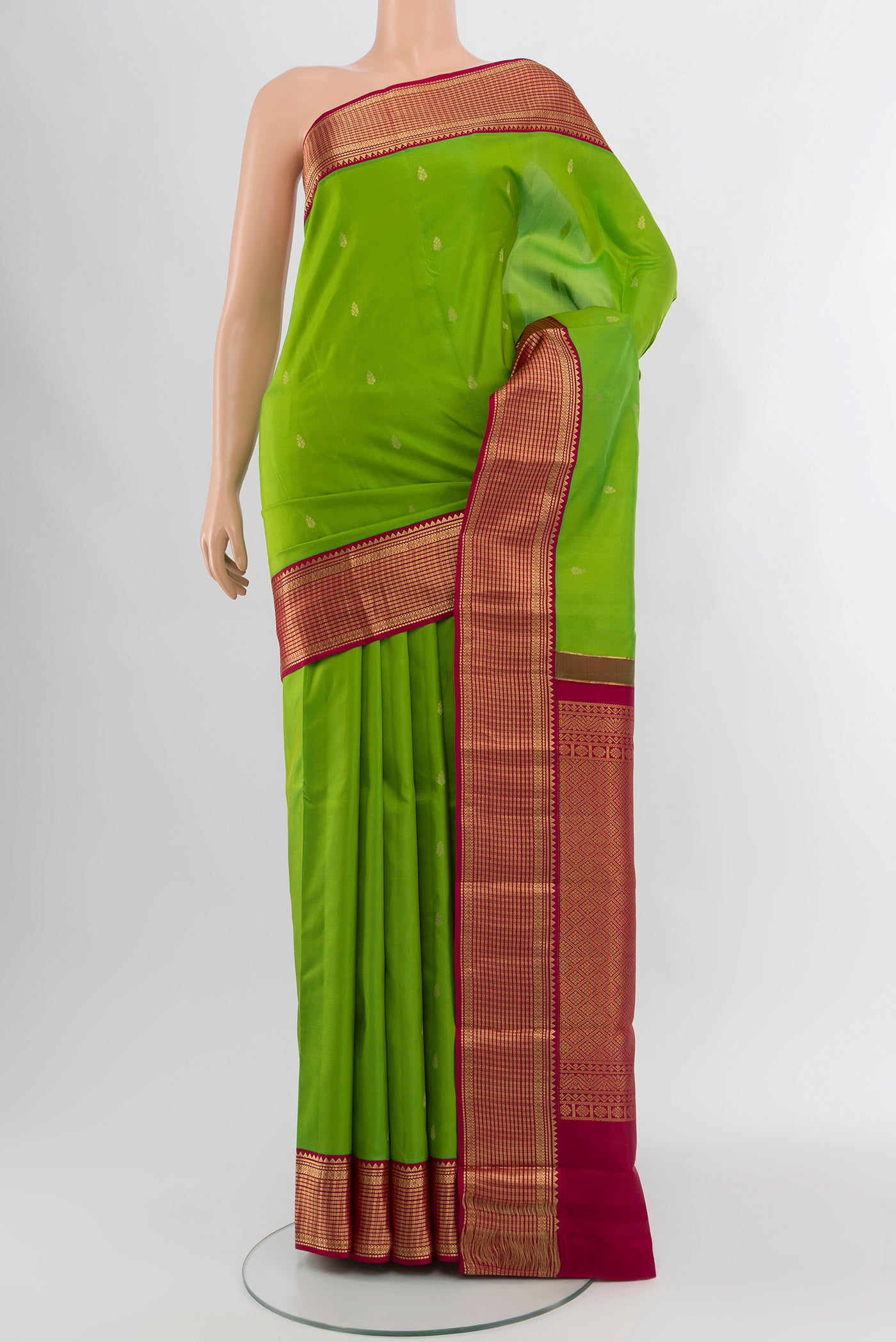 Parrot Green Kanchipuram Silk Saree with Zari Butta on the body and Zari Border.  displayed on a mannequin