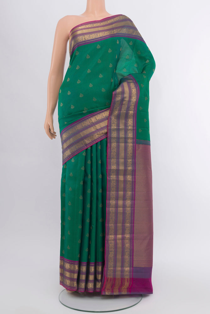 Peacock Blue Kanchipuram Silk Saree with Zari Butta on the body and Silk Border.  displayed on a mannequin