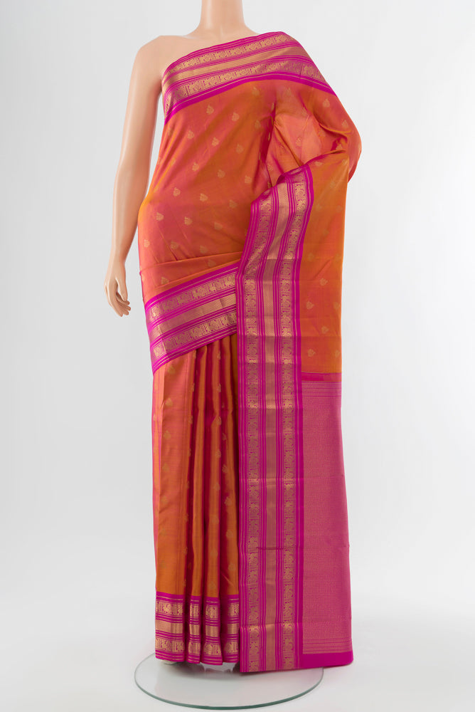 Peach Kanchipuram Silk Saree with Zari Butta on the body and Silk Border.  displayed on a mannequin