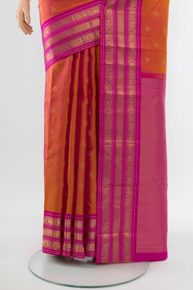 Pleats and pallu of Peach Kanchipuram Silk Saree with Zari Butta on the body and Silk Border. 