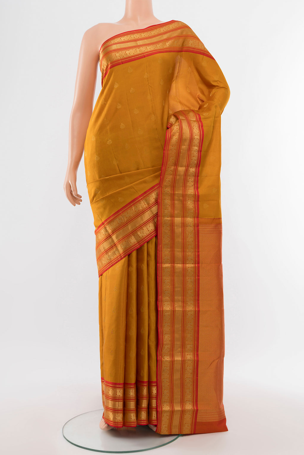Pure Silk Pure Zari Mustard Kanchipuram Saree with Zari Butta on the body and Silk Border.  displayed on a mannequin