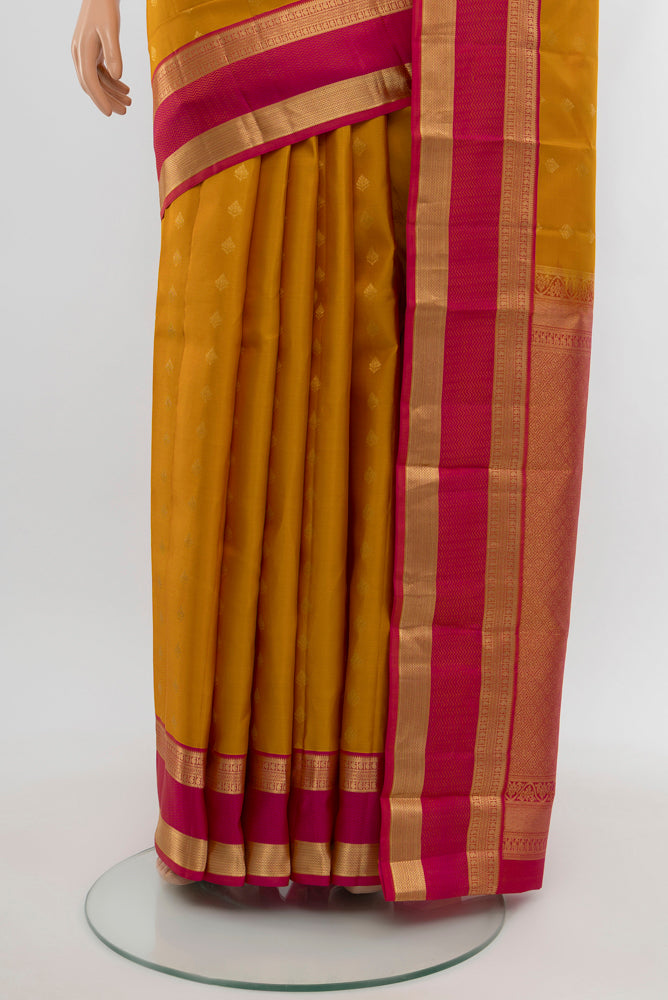 Pleats and pallu of Mustard Kanchipuram Silk Saree with Zari Butta on the body and Silk Border. 