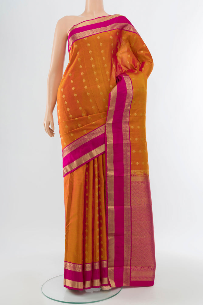 Golden Peach Kanchipuram Silk Saree with Zari Butta on the body and Silk Border.  displayed on a mannequin