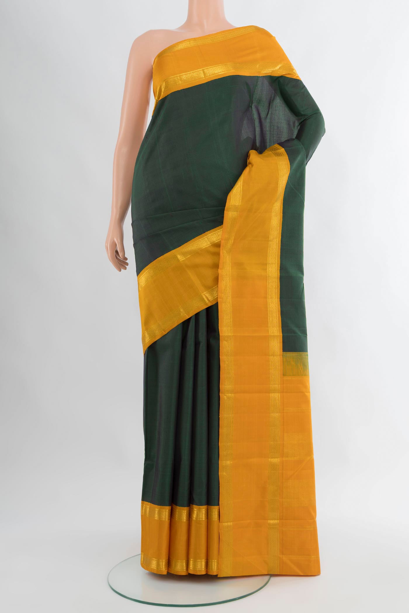 Bottle Green Kanjivaram Silk Saree with Plain Body and Zari Border.  displayed on a mannequin