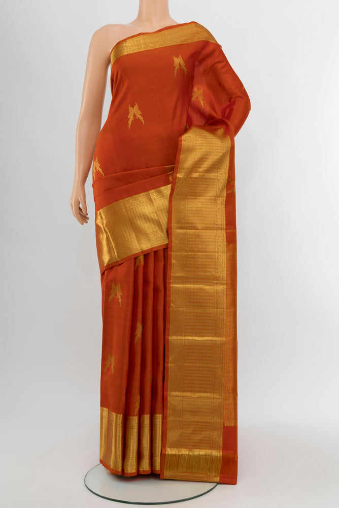 Brick Orange Kanjivaram Silk Saree with Zari Butta on the body and Silk Border.  displayed on a mannequin