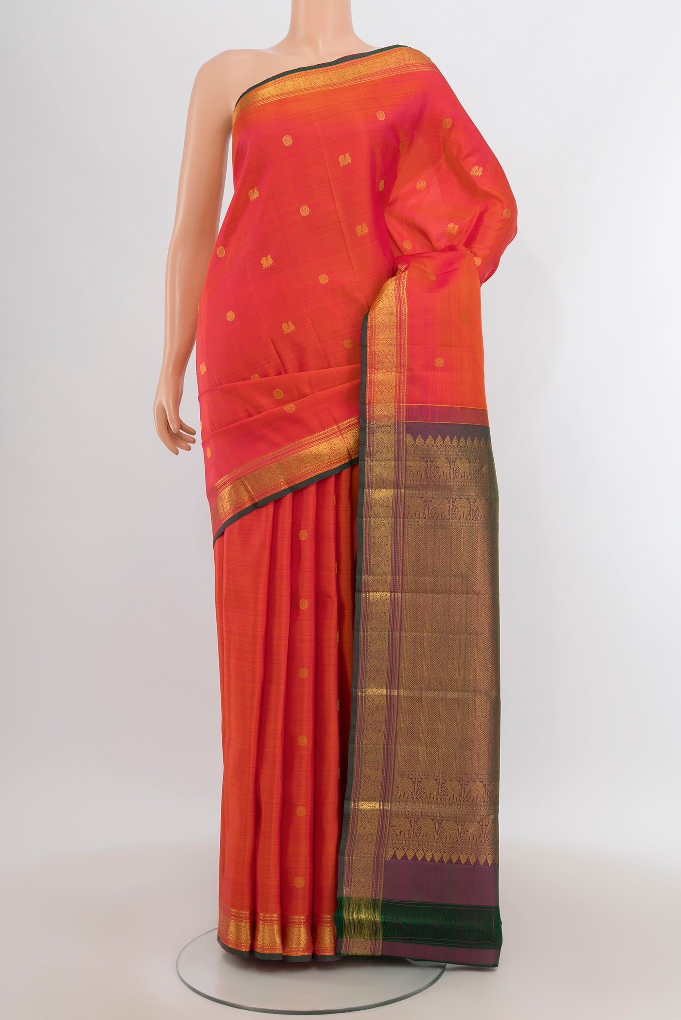 Brick Orange Kanjivaram Silk Saree with Zari Butta on the body and Zari Border.  displayed on a mannequin