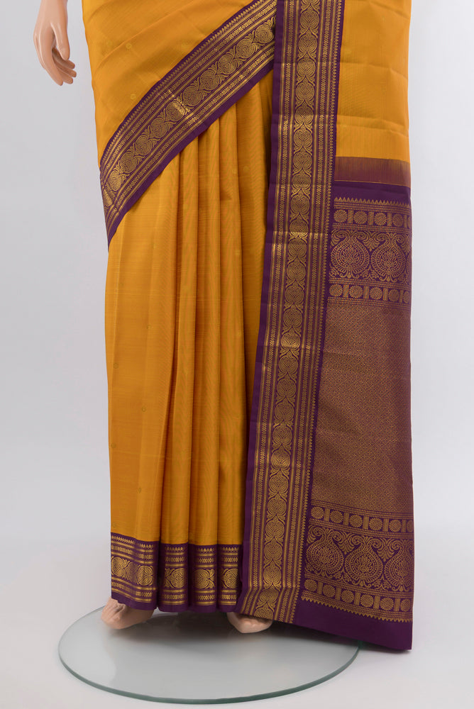 Pleats and pallu of Mustard Kanjivaram Silk Saree with Zari Butta on the body and Silk Border. 