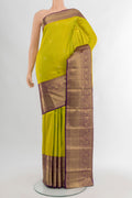 Parrot Green Kanjivaram Silk Saree with Zari Butta on the body and Zari Border.  displayed on a mannequin