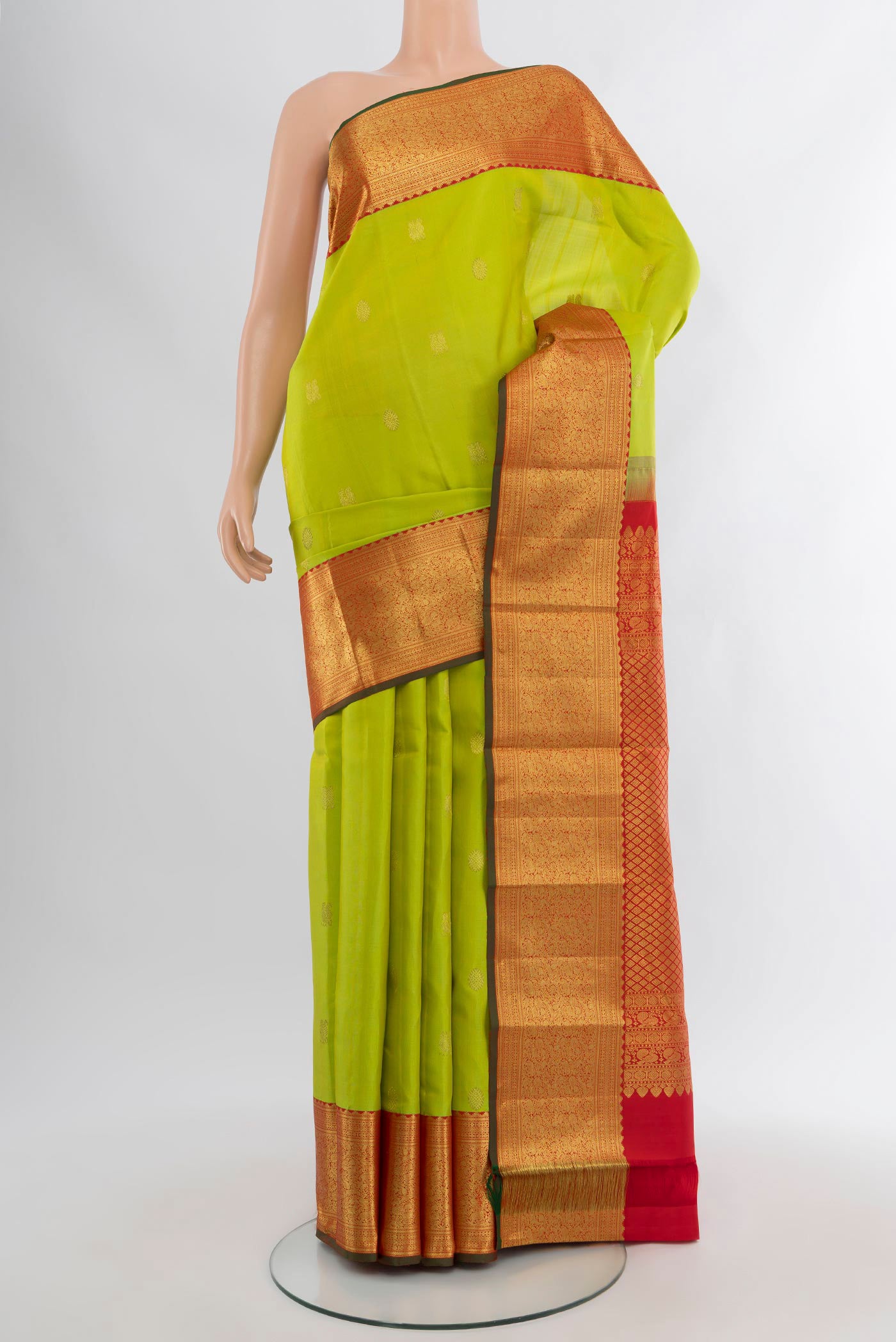 Parrot Green Kanjivaram Silk Saree with Zari Butta on the body and Zari Border.  displayed on a mannequin