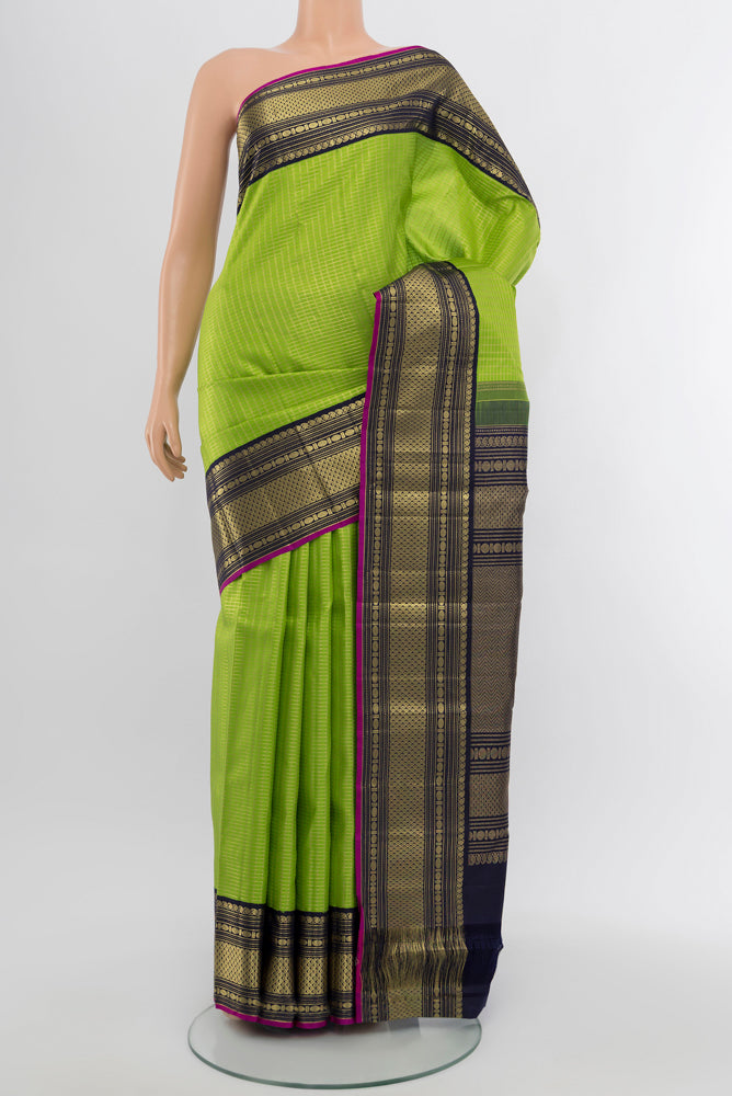 Light Green Kanchipuram Silk Saree with Zari Butta on the body and Silk Border.  displayed on a mannequin