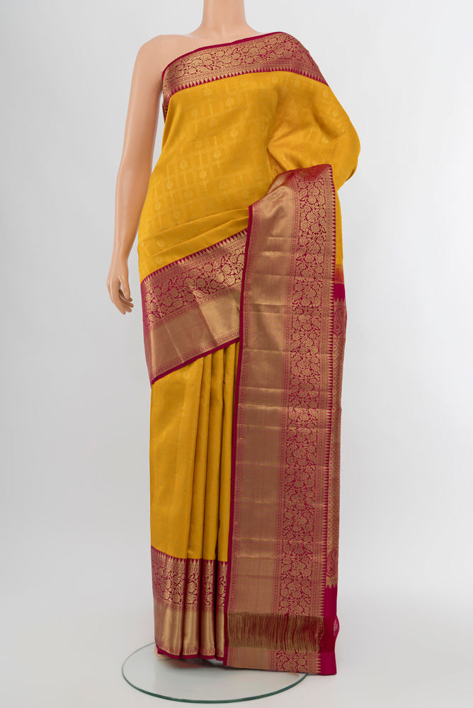 Yellow Kanchipuram Silk Saree with Zari Butta on the body and Silk Border.  displayed on a mannequin