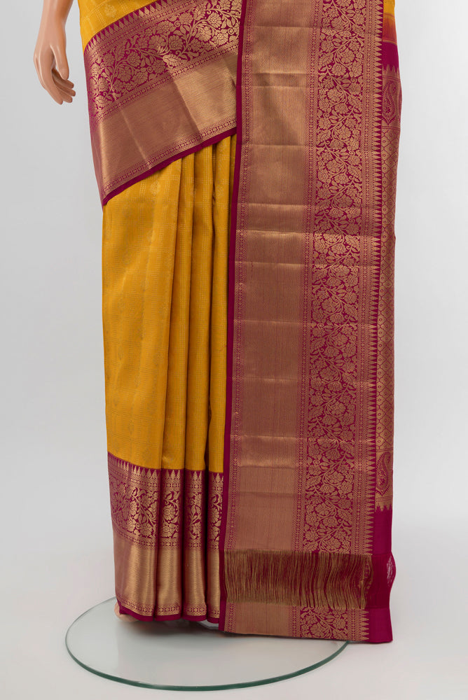 Pleats and pallu of Yellow Kanchipuram Silk Saree with Zari Butta on the body and Silk Border. 