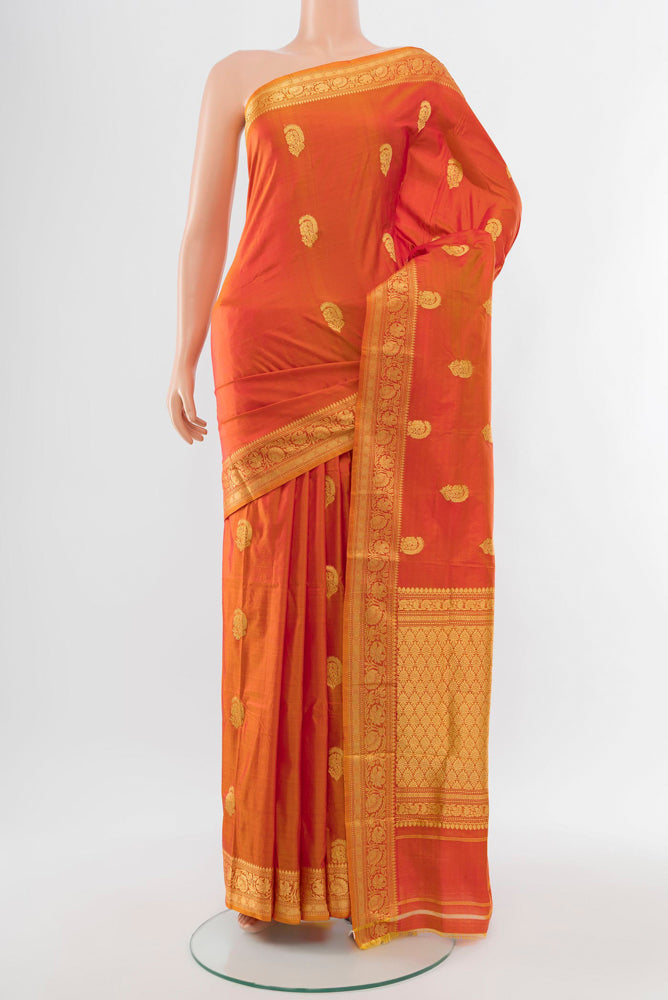 Golden Peach Banarasi Katan Silk Saree with Zari Butta on the body and Silk Border.  displayed on a mannequin