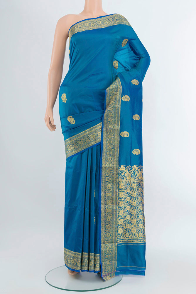 Peacock Blue Banarasi Katan Silk Saree with Zari Butta on the body and Silk Border.  displayed on a mannequin