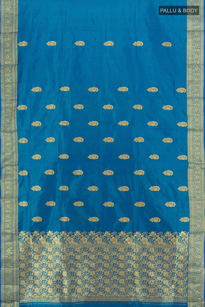 Flat view of Peacock Blue Banarasi Katan Silk Saree with Zari Butta on the body and Silk Border. 