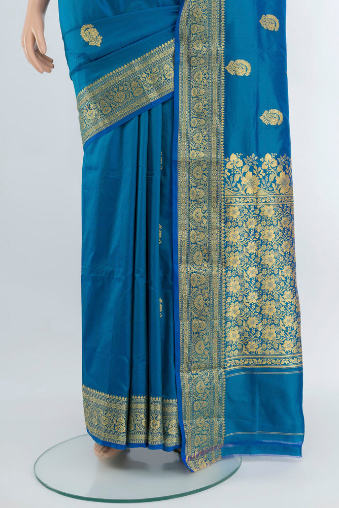 Pleats and pallu of Peacock Blue Banarasi Katan Silk Saree with Zari Butta on the body and Silk Border. 