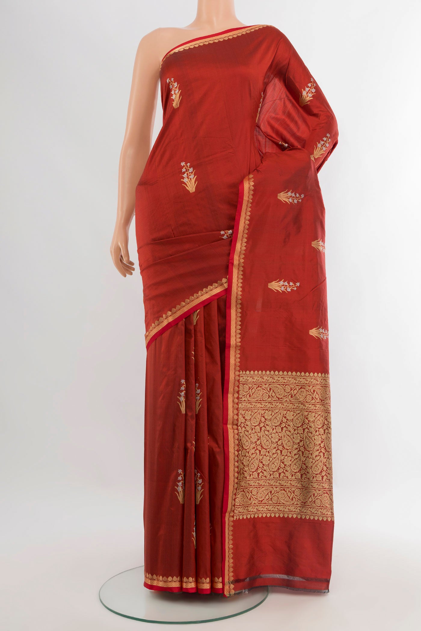 Rust Banarasi Katan Silk Saree with Zari Butta on the body and Zari And Thread Border.  displayed on a mannequin