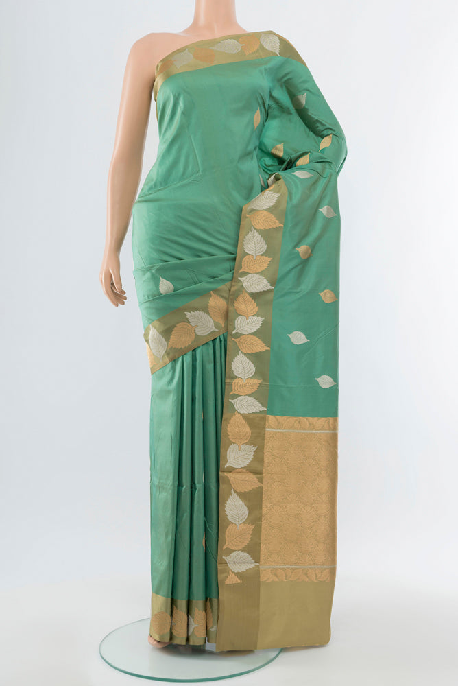 Olive Green Banarasi Katan Silk Saree with Zari Butta on the body and Silk Border.  displayed on a mannequin
