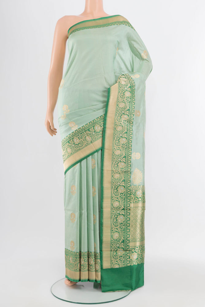 Light Green Banarasi Katan Silk Saree with Zari Butta on the body and Silk Border.  displayed on a mannequin
