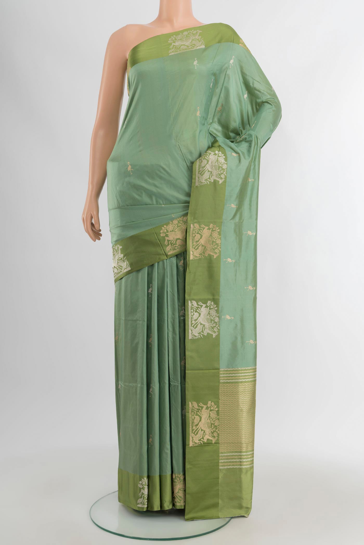 Sage Green Banarasi Katan Silk Saree with Zari Butta on the body and Temple Thread Border.  displayed on a mannequin