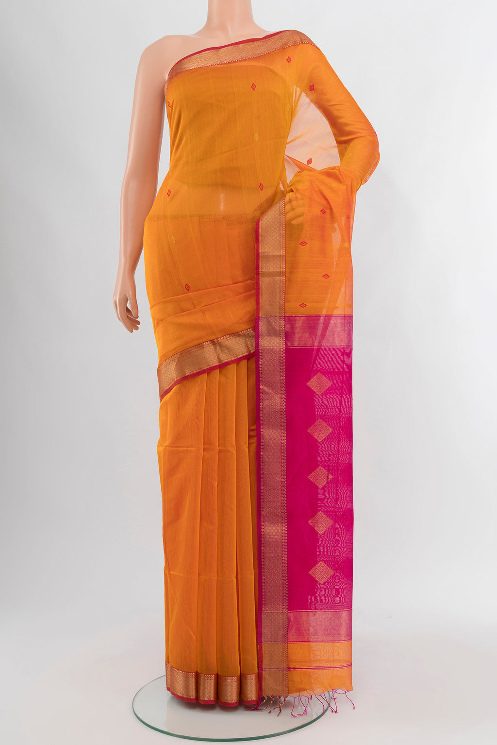 Mustard Maheshwari Silk Cotton Saree with Zari And Thread Butta on the body and Zari Border.  displayed on a mannequin