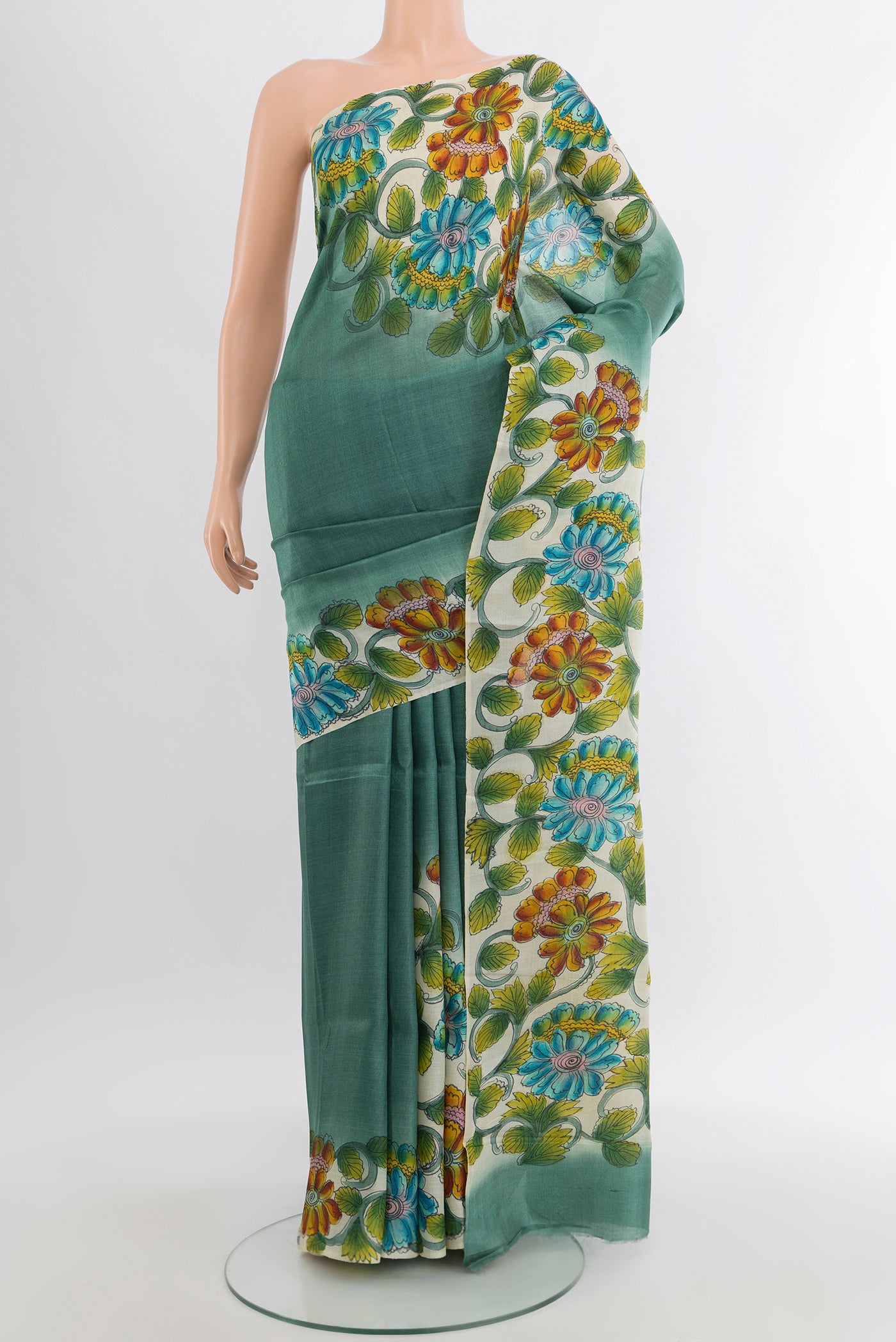 Teal Tussar Silk Saree with Floral Print on the body and Printed Border.  displayed on a mannequin