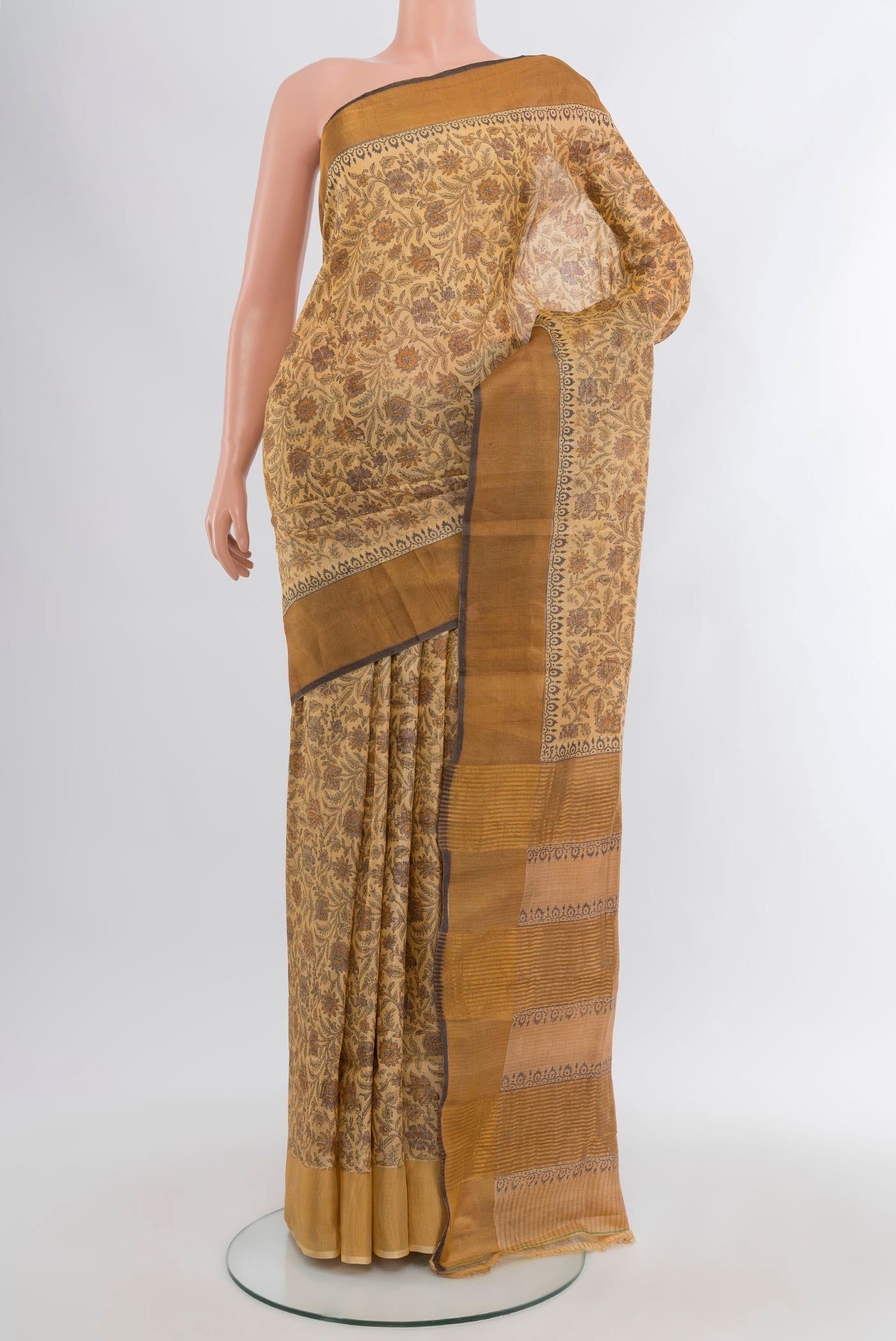 Beige Tussar Silk Saree with Floral Print on the body and Zari Border.  displayed on a mannequin