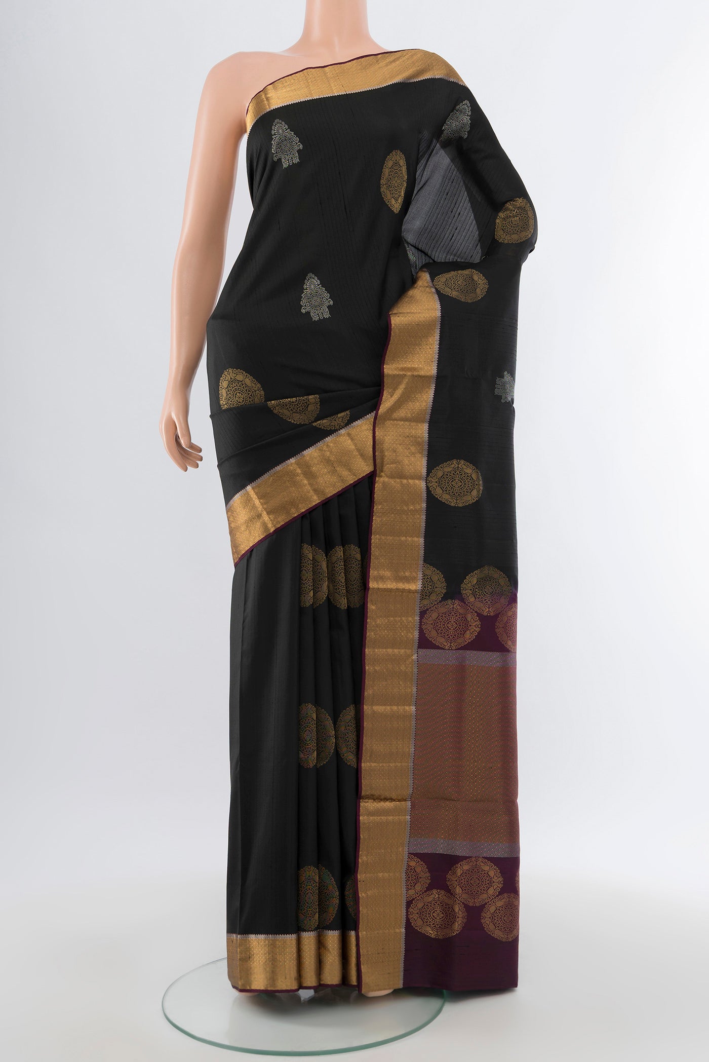 Pure Silk Pure Zari Black Soft Saree with Zari Butta on the body and Silk Border.  displayed on a mannequin
