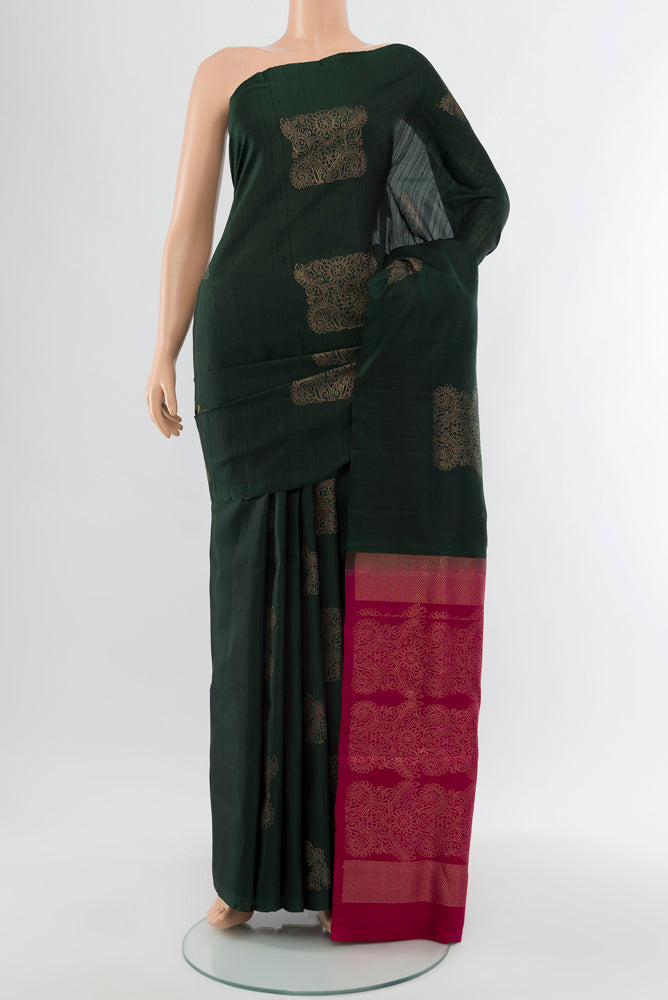 Bottle Green Soft Silk Saree with Zari Butta on the body and Silk Border.  displayed on a mannequin