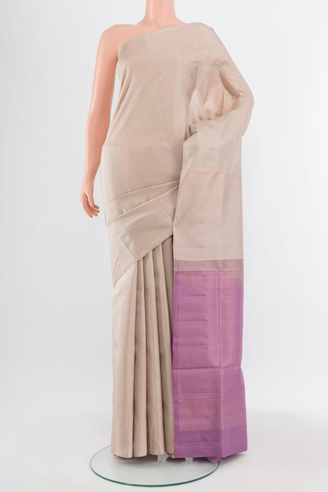 Beige Soft Silk Saree with Zari Butta on the body and Silk Border.  displayed on a mannequin