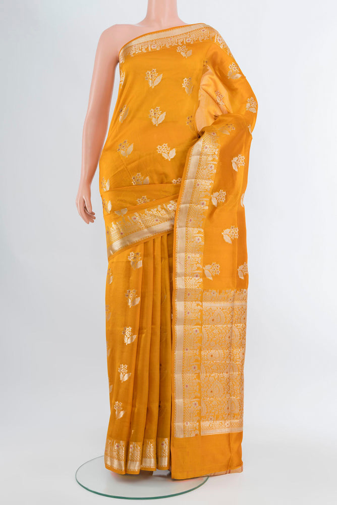 Mustard Banarasi Raw Silk Saree with Zari Butta on the body and Silk Border.  displayed on a mannequin