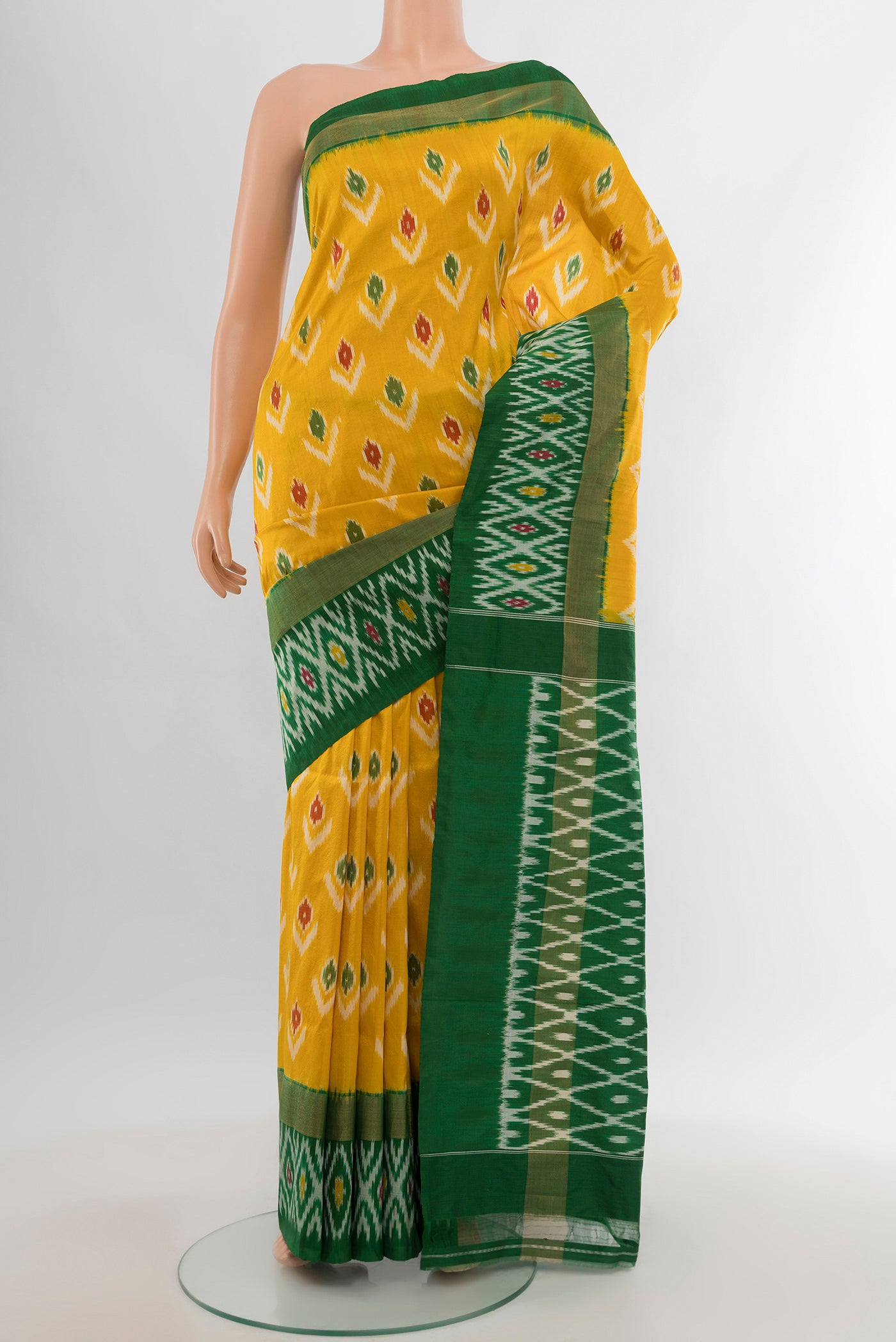 Mustard Pochampally Silk Saree with Ikat design on the body and Ikat Border.  displayed on a mannequin